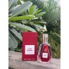 Fragrance World Lush Cherry EDP 50 ml — товар в стилизованной композиции; очень крупный план; среди зелени; самый близкий кадр