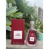 Fragrance World Lush Cherry EDP 50 ml — товар в стилизованной композиции; очень крупный план; среди зелени; самый широкий кадр