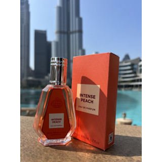 Intense peach EDP 50 ml — товар в стилизованной композиции; очень крупный план; на открытом воздухе; самый близкий кадр