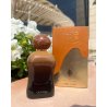 Lattafa Perfume Caramel Oud EDP 100 ml — toode ja pakend; väga lähivõte; valgel taustal