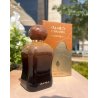 Lattafa Perfume Caramel Oud EDP 100 ml — toode stiliseeritud keskkonnas; väga lähivõte; valgel taustal