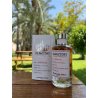 Olfactory Bonfire EDP 100 ml — prodotto in un’ambientazione stilizzata; dettaglio molto ravvicinato; tra il verde