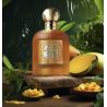 Paris Corner Mango Punch EDP 100 ml — товар в стилизованной композиции; очень крупный план; среди зелени