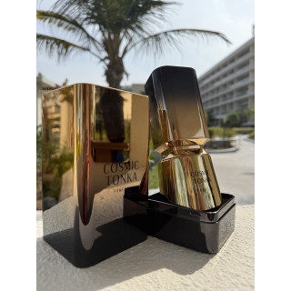 Fragrance World Cosmic Tonka EDP 100 ml — produkt w stylizowanej aranżacji; bardzo bliskie ujęcie; wśród zieleni