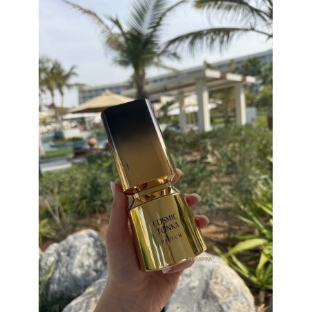 Fragrance World Cosmic Tonka EDP 100 ml — produkt w stylizowanej aranżacji; bardzo bliskie ujęcie; na kamiennej powierzchni