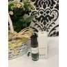 Lattafa Perfume Interlude EDP 30 ml — toode stiliseeritud keskkonnas; väga lähivõte; roheluse keskel