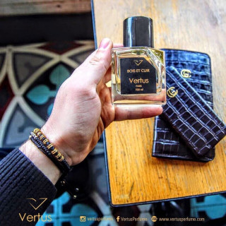 Bois Et Cuir EDP 100 ml — товар в стилизованной композиции; очень крупный план; на деревянной поверхности