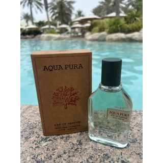 Fragrance World Aqua Pura EDP 70 ml — produkts stilizētā vidē; ļoti tuvs plāns; starp zaļumiem