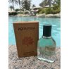 Fragrance World Aqua Pura EDP 70 ml — produkt w stylizowanej aranżacji; bardzo bliskie ujęcie; wśród zieleni