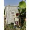Lattafa Perfume Shahrazad EDP 100 ml — toode stiliseeritud keskkonnas; väga lähivõte; roheluse keskel; lähim kadreering