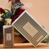 Lattafa Perfume Ajeeb EDP 100 ml — produkt w stylizowanej aranżacji; bardzo bliskie ujęcie; wśród zieleni; najszersze kadrowanie