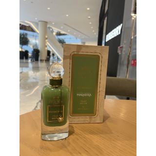 Lattafa Perfume Pistachio Musk EDP 100 ml — produkts stilizētā vidē; ļoti tuvs plāns; uz koka virsmas; vidējs kadrējums