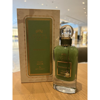 Lattafa Perfume Pistachio Musk EDP 100 ml — produkts stilizētā vidē; ļoti tuvs plāns; uz koka virsmas; visplašākais kadrējums