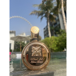 Fakhar Extrait Gold 100 ml — товар в стилизованной композиции; очень крупный план; среди зелени; самый близкий кадр