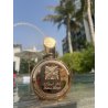 Fakhar Extrait Gold 100 ml — товар в стилизованной композиции; очень крупный план; среди зелени; самый близкий кадр