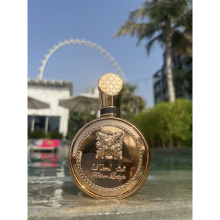 Fakhar Extrait Gold 100 ml — товар в стилизованной композиции; очень крупный план; среди зелени; самый широкий кадр