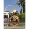 Fakhar Extrait Gold 100 ml — товар в стилизованной композиции; очень крупный план; среди зелени; самый широкий кадр