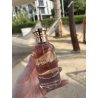 Fragrance World Roses De Mai Jacques Yves EDP 100 ml — produktas stilizuotoje aplinkoje; stambus planas; žalumos apsuptyje